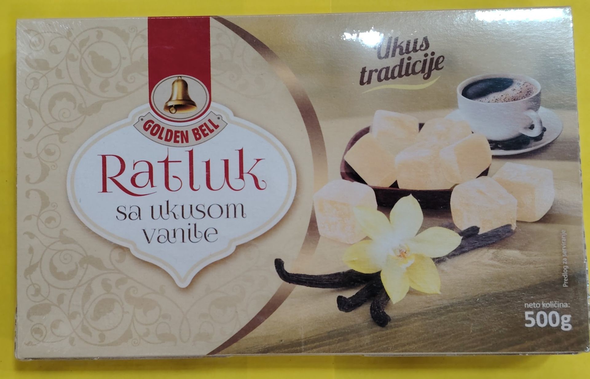 Packaging of Golden Bell vanilla-flavored Turkish delight with a cup of coffee and vanilla flower decoration.